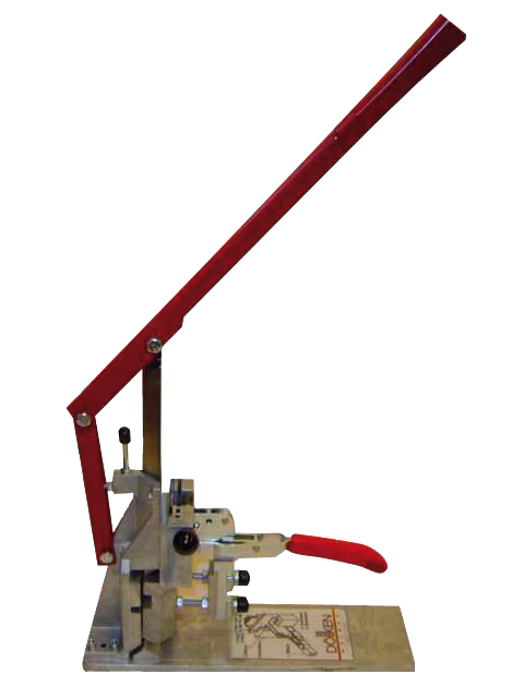WOLFF_Dummy_15915_skirting board punching machine_2025-08 Ręczna prasa stołowa z długim czerwonym dźwignią i małym czerwonym uchwytem, zamontowana na metalowej podstawie, używana do wykrawania lub prasowania małych elementów. Prasa ma przegubowe ramię, regulowane elementy i prostokątną płytę podstawy z nadrukowanymi instrukcjami.